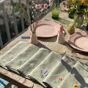 Napkins, plates and flowers on table
