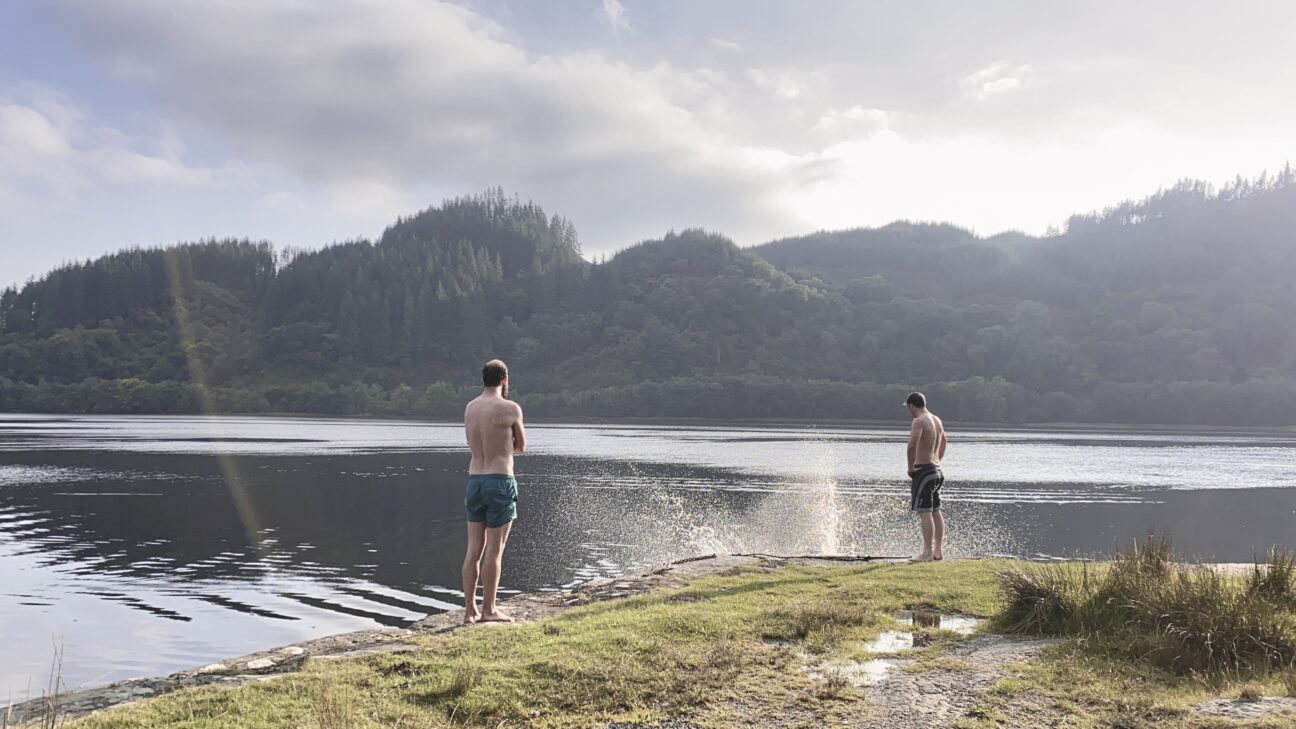 Two people standing next to a lake